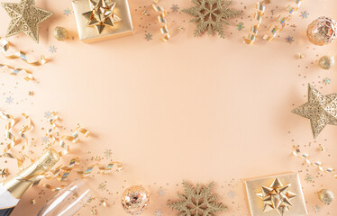 Happy New year celebration background concept. Golden gift box, stars, christmas ball and champagne on pastel background. Flat lay, top view with copy space.