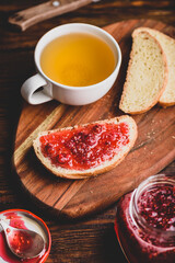 Toast with homemade raspberry jam with cup of green tea