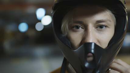 Fototapeta na wymiar Portrait of young blonde woman with safety helmet in underground parking garage. High quality photo