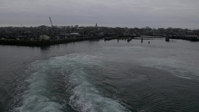 Ferry Leaving Nantucket Island Harbor on gray cloudy day with heavy stormy clouds, deck view