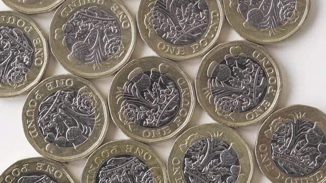 Flat Lay Of British One Pound Coins On White Background - Closeup Shot Vertical