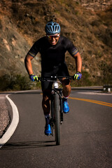 Fototapeta na wymiar Latino riding a bike through the valleys