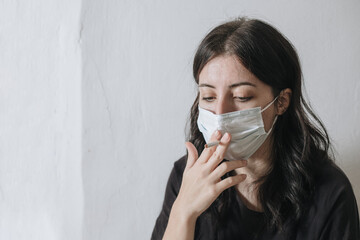 Armenian smoker tries to smoke through a mask from coronavirus, but she does not work out and she is sad