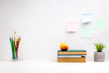 white study desk background backdrop. books for learning, stationery on a tabletop. offline home workplace. side view