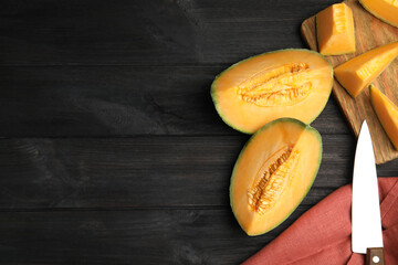 Tasty fresh cut melon on black wooden table, flat lay. Space for text
