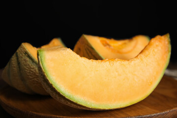 Tasty fresh cut melon on wooden tray, closeup