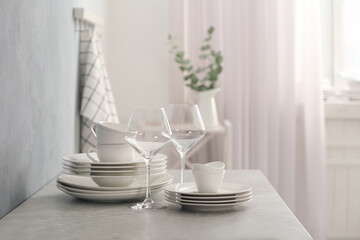 Fototapeta na wymiar Set of clean dishware and wineglasses on grey table indoors