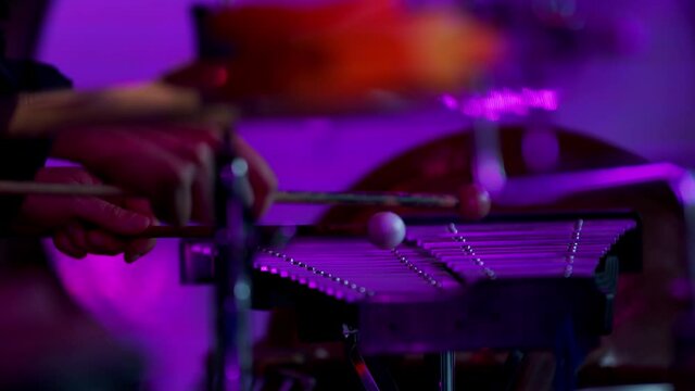 Drummer is playing xylophone at a concert, purple lighting, 4k