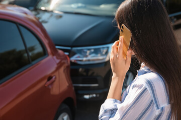 Fototapeta na wymiar Young woman talking on phone after car accident outdoors, closeup