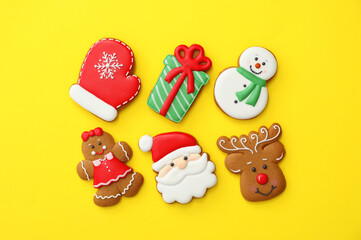 Different Christmas gingerbread cookies on yellow background, flat lay