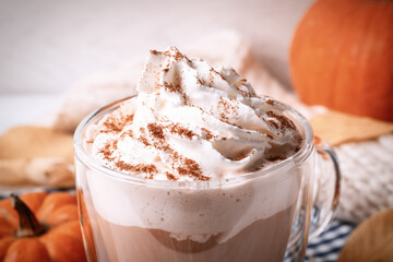 Delicious pumpkin latte with whipped cream on table, closeup