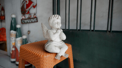 Christmas wooden white colorize toy of angel sits on a chair