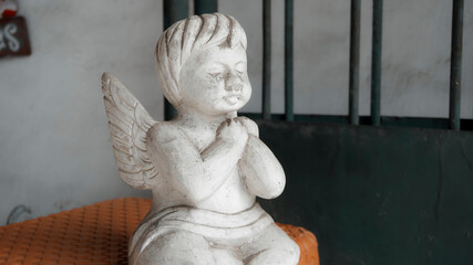 Christmas wooden white colorize toy of angel sits on a chair in the house