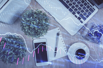 Multi exposure of financial chart hologram over desktop with phone. Top view. Mobile trade platform concept.