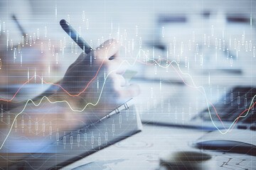 Double exposure of forex graph drawing over people taking notes background. Concept of financial analysis