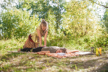 Girl masseuse provides a thorough massage outside.