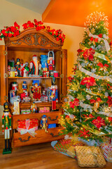 Christmas presents, nutcrackers and Santa Claus and a Christmas tree fill a room.