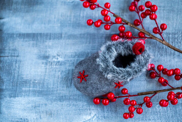 Christmas decoration sock, red berries on wooden background
