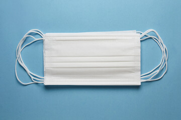 Surgical mask with rubber ear straps on blue background