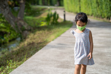 Little girl walking at street with protective face mask to prevent virus and pm2.5