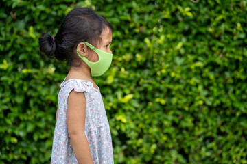 Little girl walking at park with healthy face mask to prevent virus and pm2.5