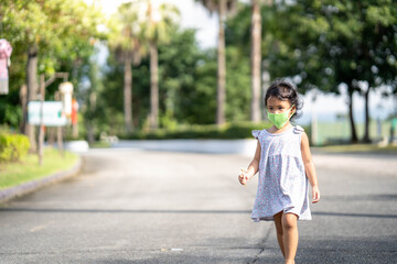 Little girl walking at street with protective face mask to prevent virus and pm2.5