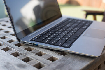 Modern silver opened laptop on the old wooden table.