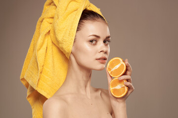 Beautiful woman yellow towel on orange natural cosmetics Exotic beige background