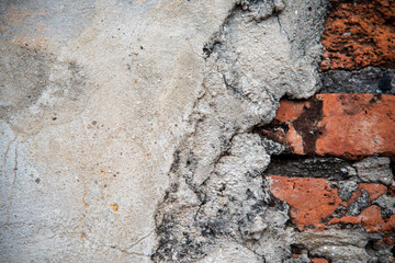 Closeup of brick wall with half of thick cement
