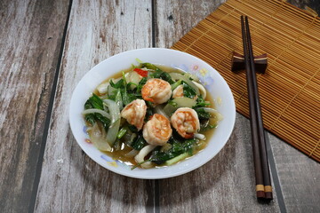Fried and stirred spicy fresh peeled shrimp with chilly, sliced onion and spring onion seasoning with pepper and soy sauce on the plate. Famous traditional spicy seafood menu in Asia restaurant. 