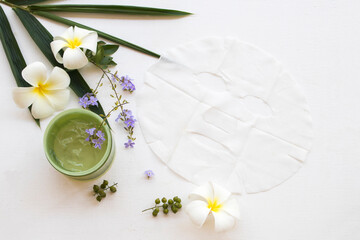 natural cosmetics herbal soothing gel and sheet mask aroma face mask from bamboo health care for skin face with bamboo leaf ,frangipani ,purple flower decoration flat lay style on background white 