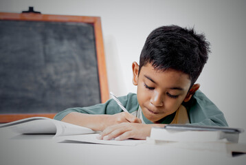 Schoolboy doing his study and homework at bedroom  - obrazy, fototapety, plakaty