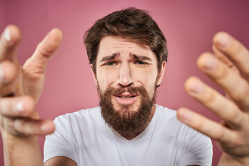 bearded man in white t-shirt emotions displeased facial expression studio pink background