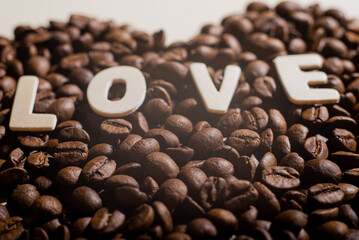 Close-up of coffee beans in the shape of a heart and the inscription love