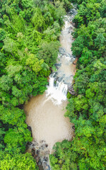 Aerial top view perspective of waterfall in tropical rainforest.
