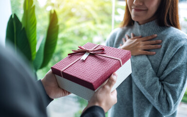 A boyfriend surprising and giving his girlfriend a gift box