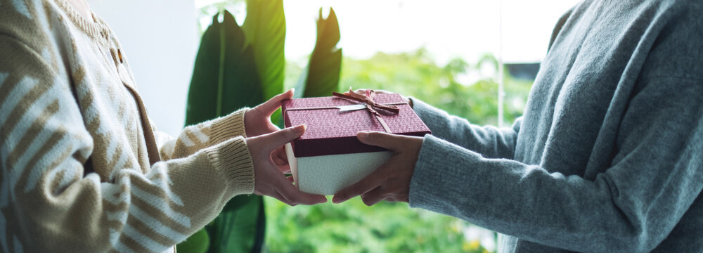 Closeup Image Of A Women Giving Friend A Gift Box