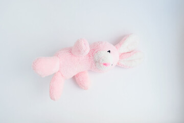 pink rabbit soft toy on a light solid background