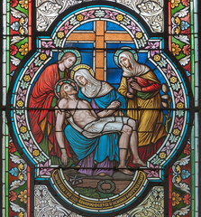 VIENNA, AUSTIRA - OCTOBER 22, 2020: The Deposition - Pieta on the stained glass in  in church...