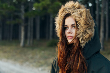 Woman warm jacket with a hood admires the nature fresh air trees travel