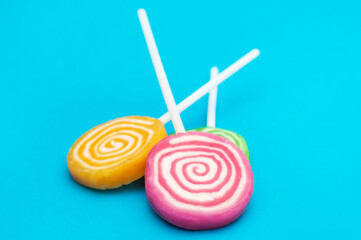 Lollipops on stick on blue background.