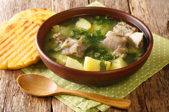 Colombian traditional menu Caldo de costilla soup with beef ribs, potatoes close-up in a bowl on the table. horizontal