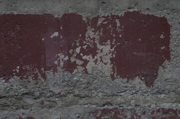 Photo of an old texture wall. The paint was crumbling. Cracks, fractures, and dents. In shades of grey and red Bordeaux.
