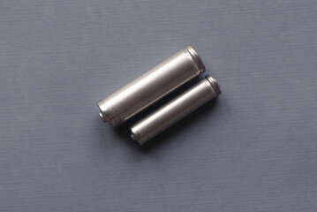 Top view of AA and AAA battery on a grey background.