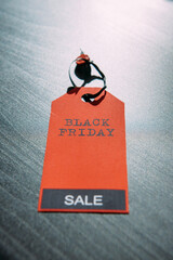 Red tag with inscription on dark wooden background in stylish design, close-up. Concept of black...