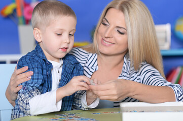 Woman and little boy playing with puzzles