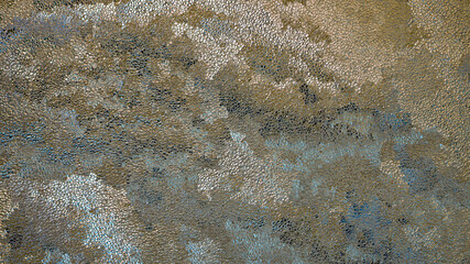 Abstract grainy background in brown and blue colors. Chaotic spots and streaks, like storm clouds or puffs of smoke. Tinted dark backdrop or wallpaper. Surface of ice crystals close up
