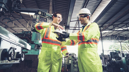 Factory worker warn coworker about safety and give hardhat to him . Injury prevention and safety first concept .