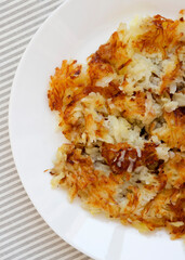 Homemade Fried Hashbrowns on a white plate, top view. Flat lay, overhead, from above. Close-up.