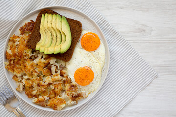 Tasty Homemade Fried Hashbrowns and Eggs on a plate, top view. Flat lay, overhead, from above. Copy space.